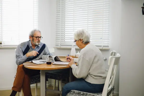 Monte-escalier à Clisson : couple de retraités préparant leur dossier d'aide à la table du séjour